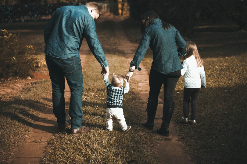 family holding hands walking at dusk